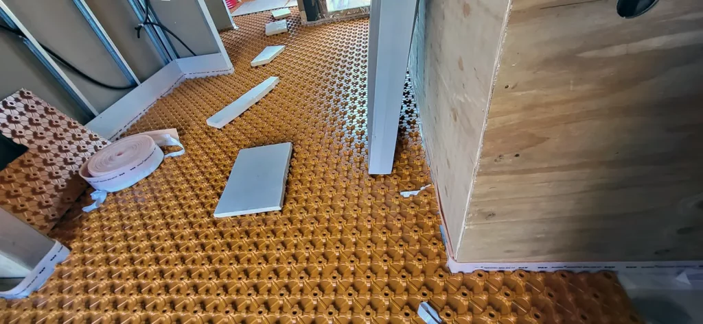 Zona d’instal·lació de sòl radiant amb panells i materials de muntatge.