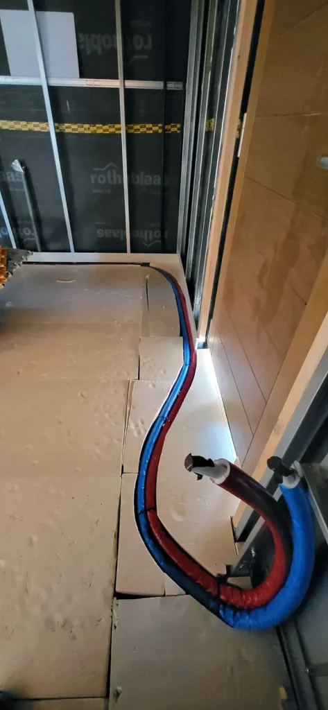 Conducció de tubs d’aigua d’una instal·lació d’aerotèrmia a través del terra.