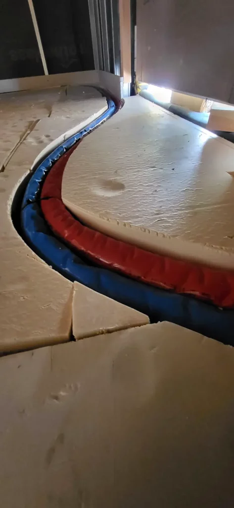 Tuberías de impulsión y retorno embutidas en el aislamiento térmico del suelo.