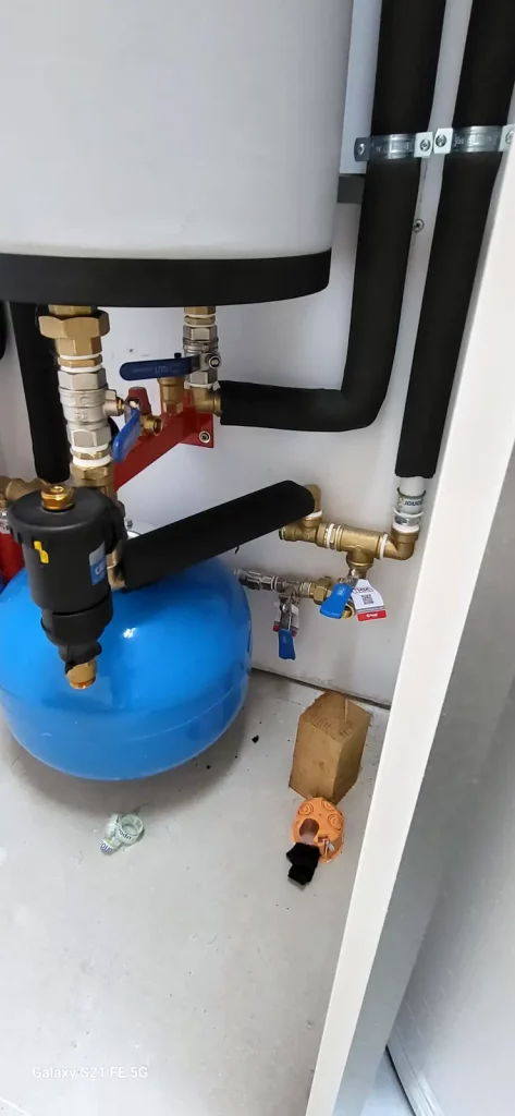 Detalle de las conexiones hidráulicas de la aerotermia con el depósito de inercia.