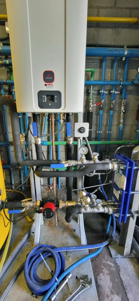 Instalación de caldera mural en cuarto técnico con sistema de distribución hidráulica.