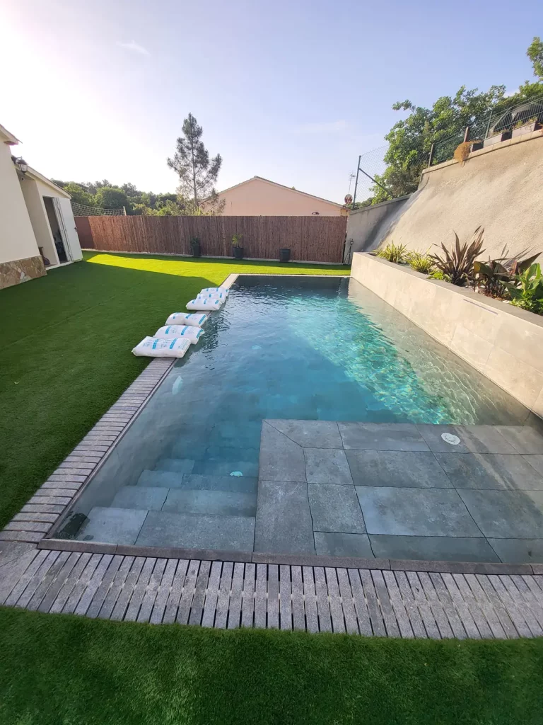 Piscina privada con sacos preparados para el mantenimiento del agua.