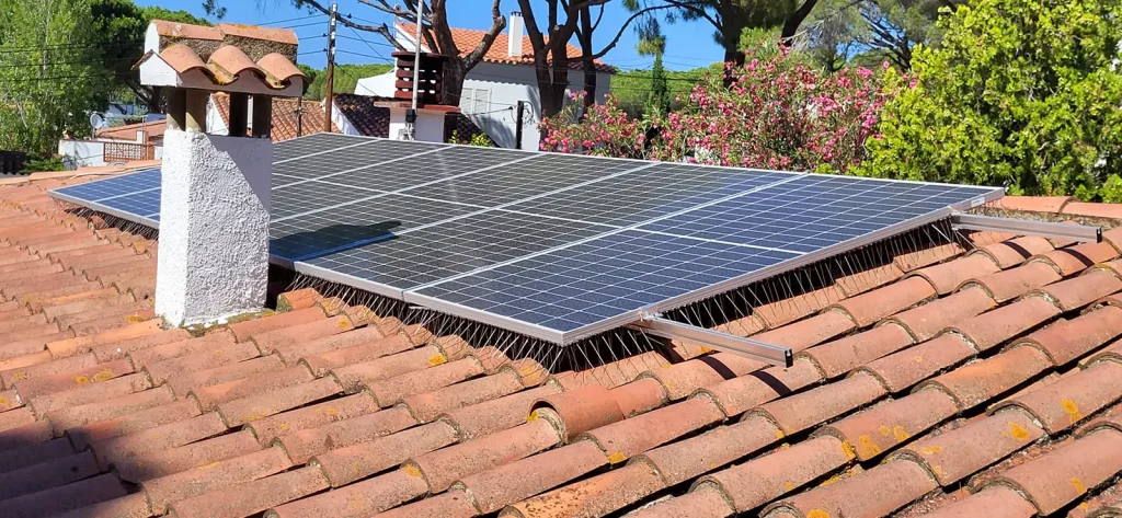 Placas solares fotovoltaicas sobre tejado de teja con protección antivaho para aves.