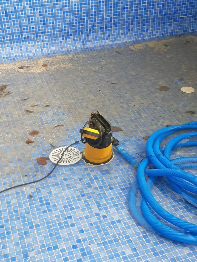 Limpieza del fondo de la piscina con bomba extractora de agua.