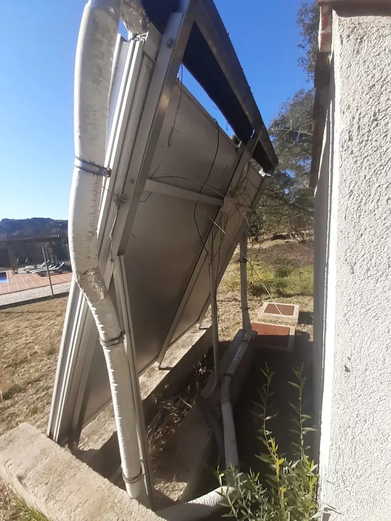 Vista trasera de paneles solares térmicos instalados sobre estructura metálica.